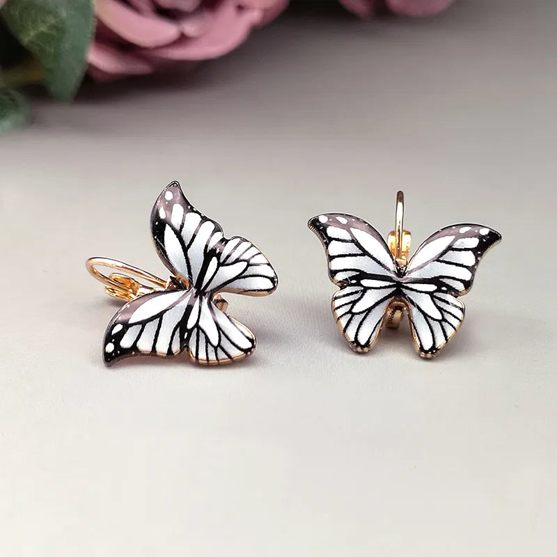 A pair of colorful butterfly stud earrings with gold-colored alloy, showcasing vibrant patterns.